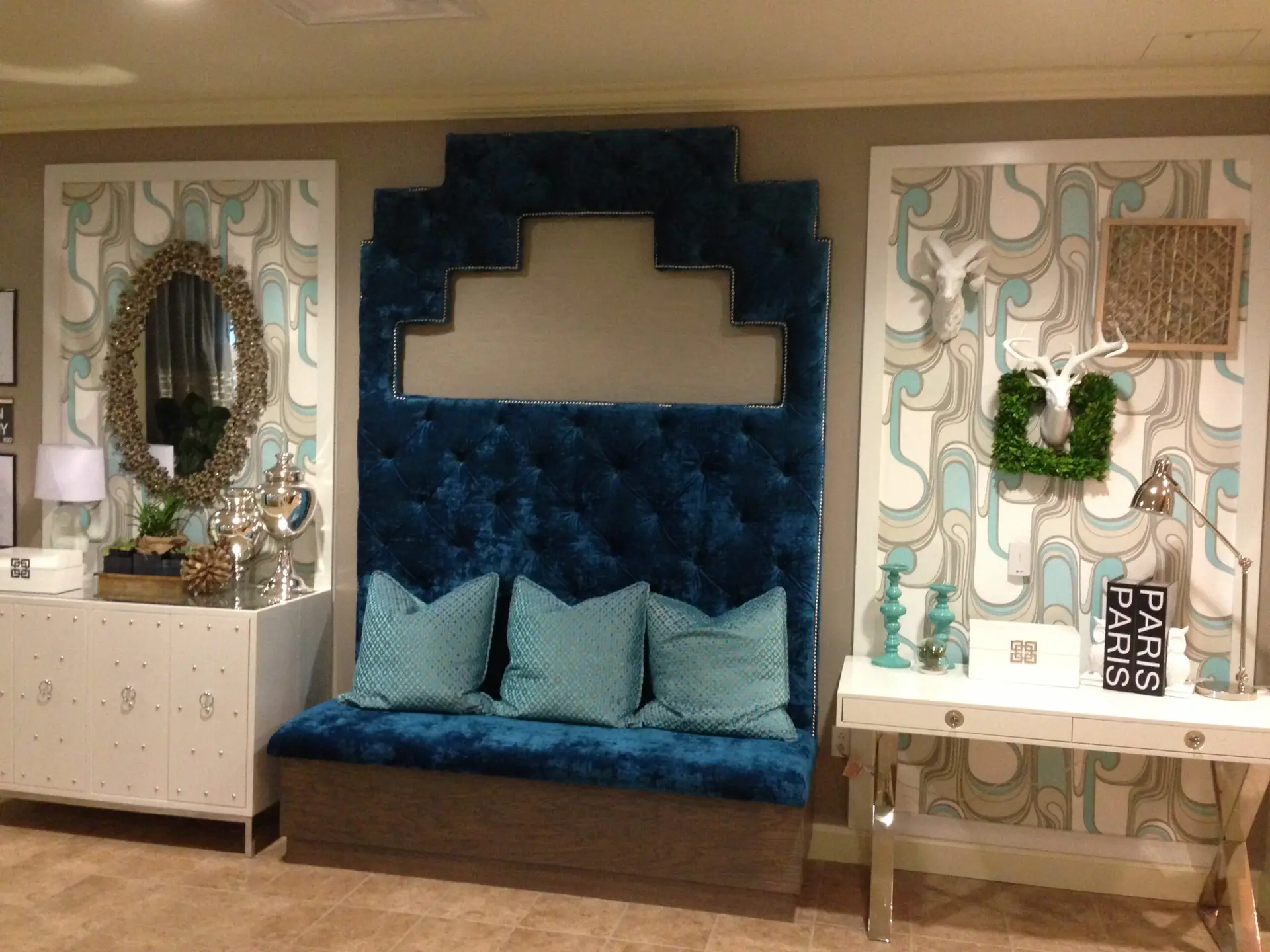 Boutique seating area with a tufted banquette, mirrors and display consoles