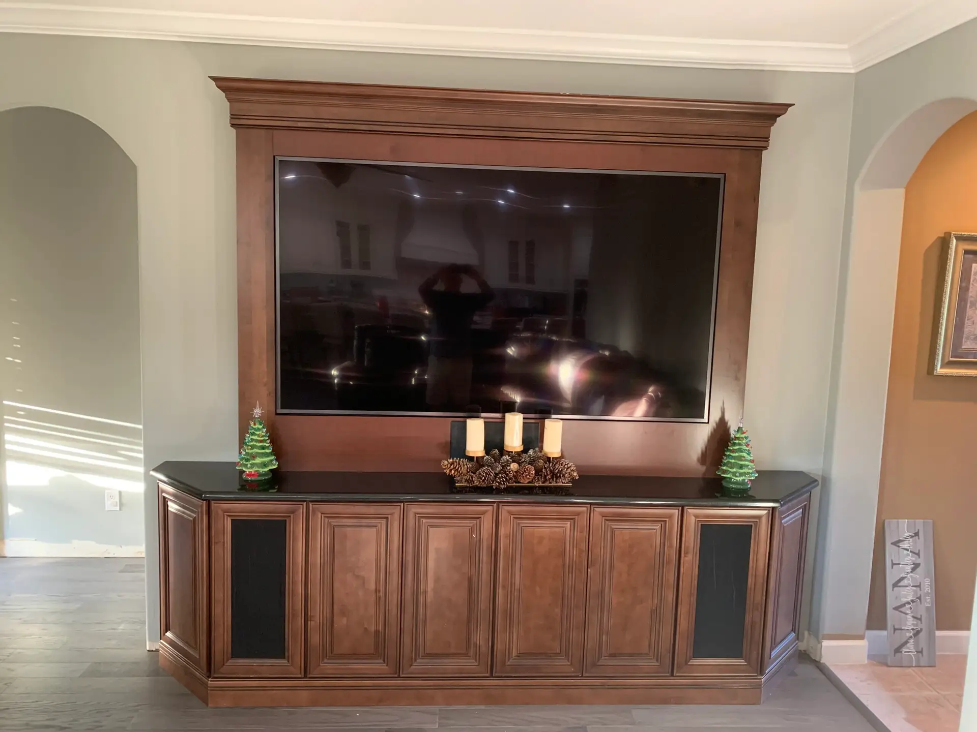 Custom wood media cabinet with crown molding and a recessed display surround