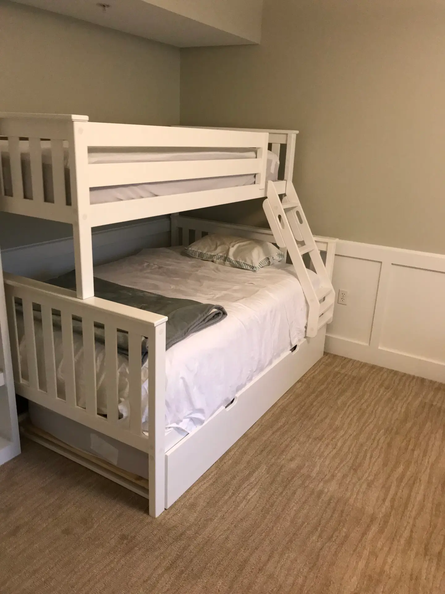 Custom-built bunk beds with an integrated shelving tower in a finished bedroom
