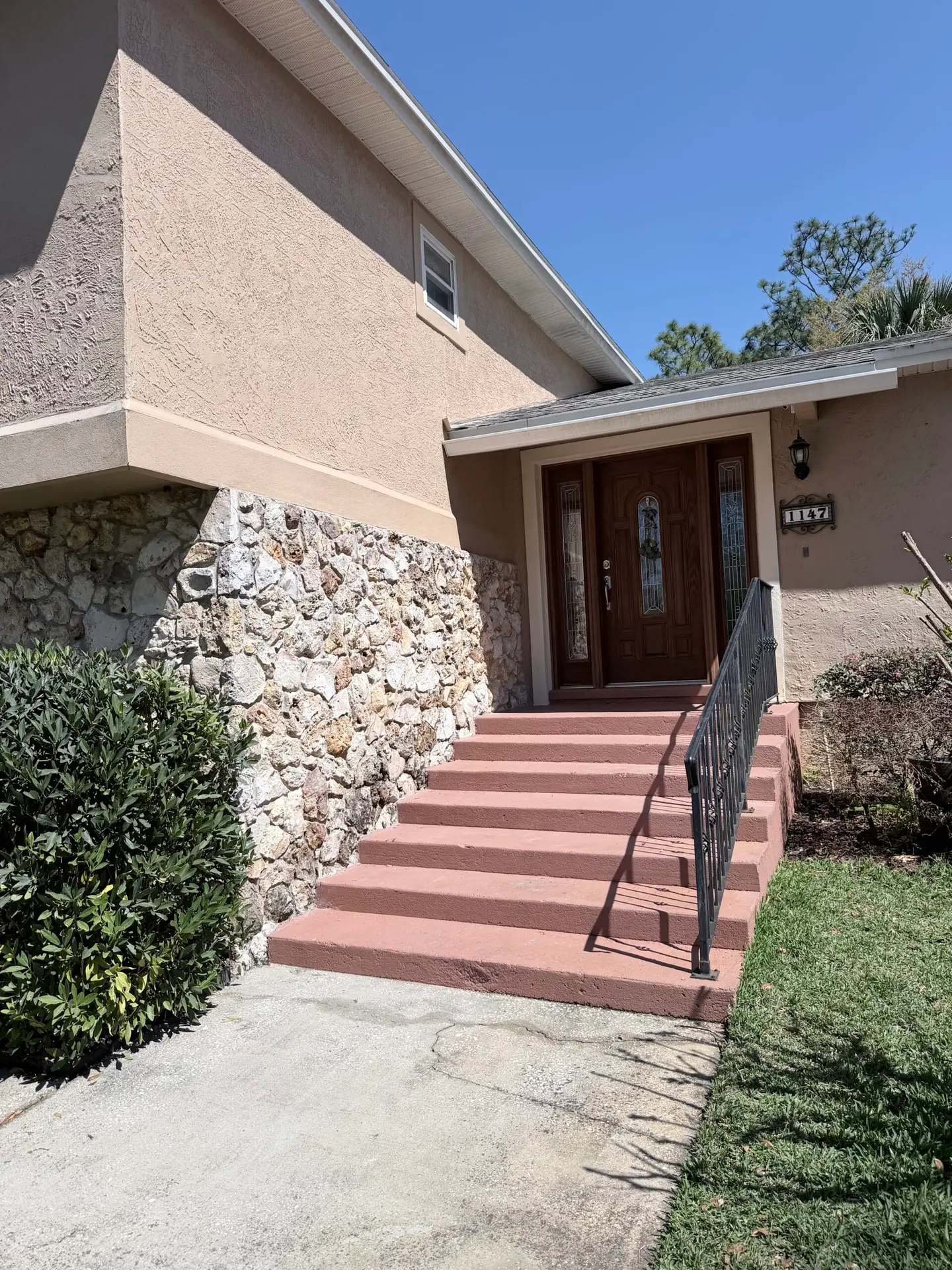 Older home exterior with a stone-faced facade and brick front steps