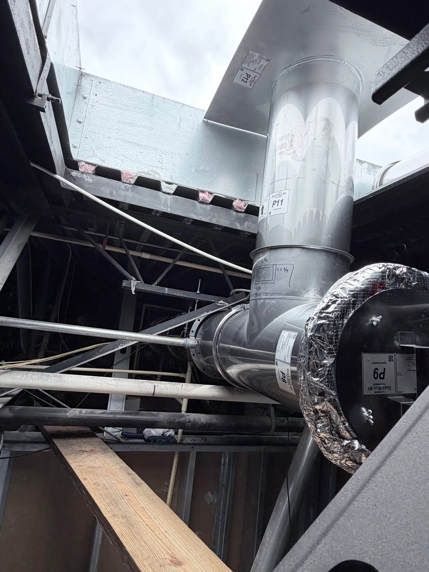Spiral HVAC ductwork and damper connection above an open ceiling