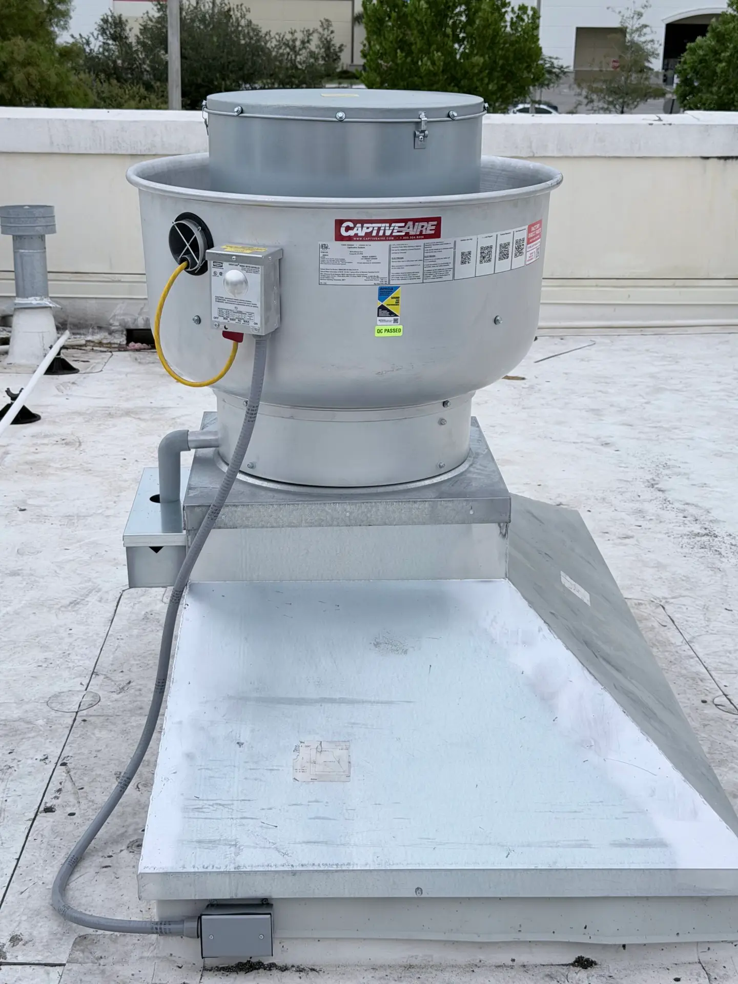 Rooftop exhaust fan mounted on a new curb during mechanical installation