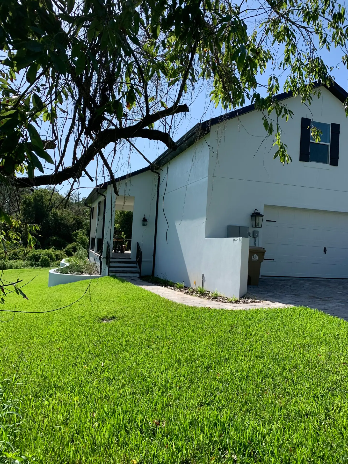 Single-story home exterior with an attached garage and mature landscaping