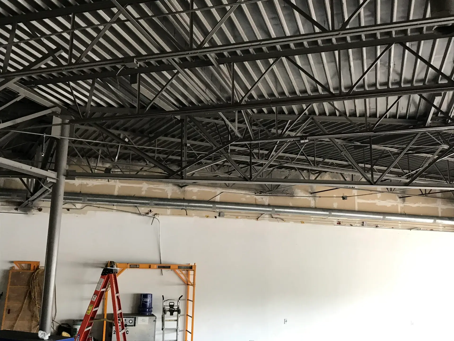 Commercial shell interior with exposed structural joists before buildout begins