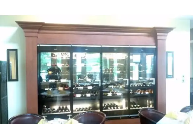 Glass-front display cabinetry built into a commercial bar and lounge area