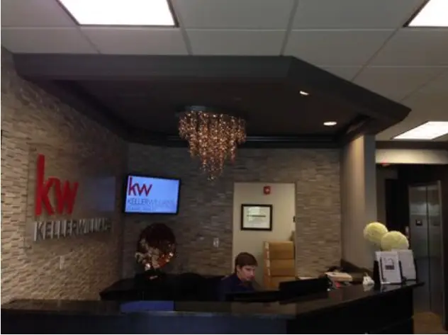 Finished commercial reception desk with a stone-clad front and decorative lighting