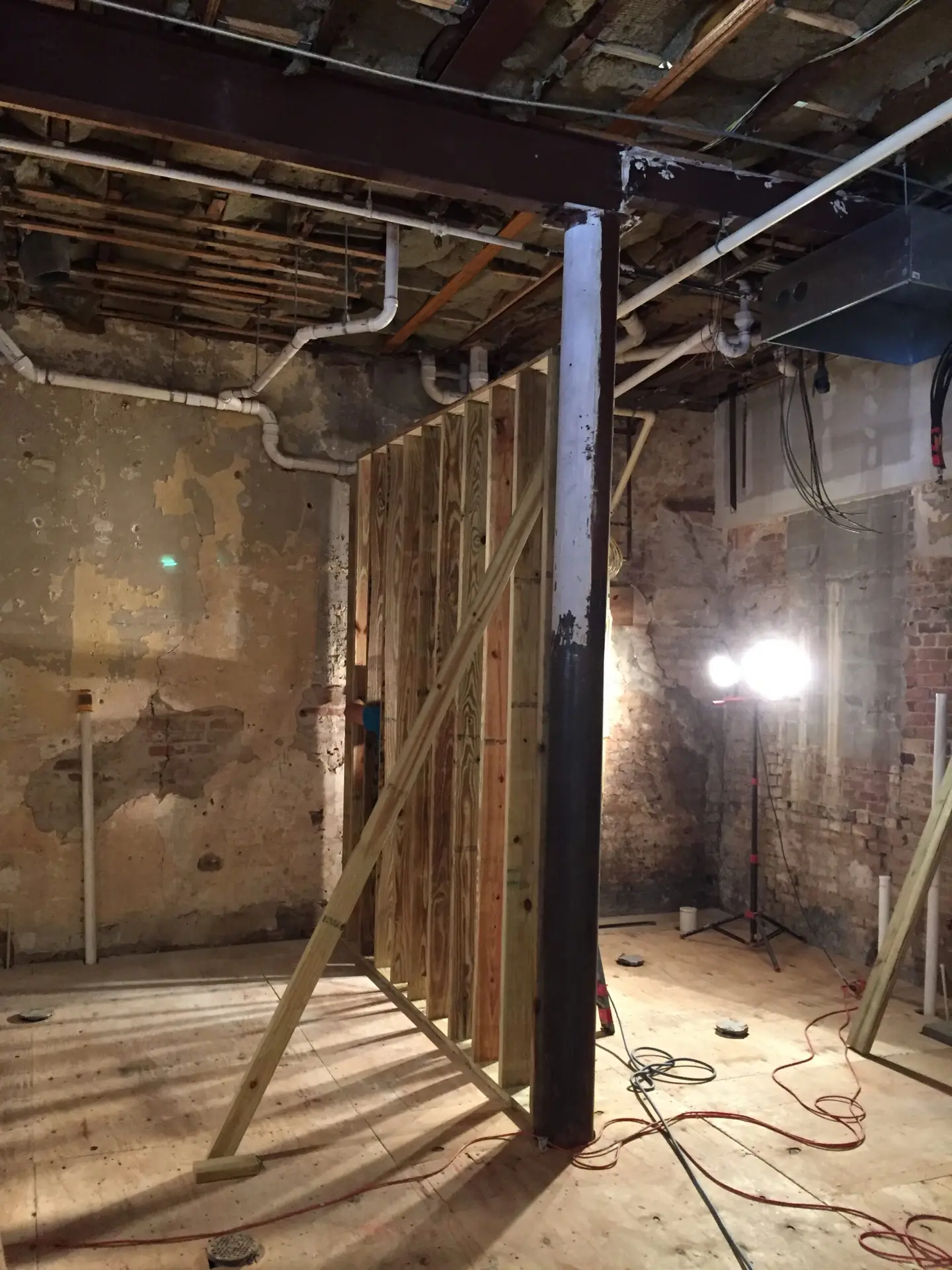 Interior stripped to the studs during demolition, exposing framing and overhead services