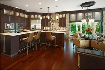 Finished kitchen with dark wood cabinetry, an island with seating and pendant lighting